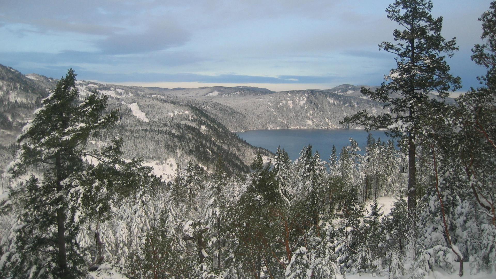 Snowy landscape of a mountainous area near a river.
